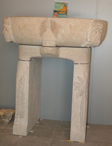 Lavabo en pierre sculpté sur le thème kanak ( Nouvelle Calédonie). An milieu une case traditionnelle coiffée d'une flèche faîtière. La case construite sur un rocher est protégée des mauvais esprits par 2 totems. le soleil en arrière plan nous rappelle son climat...