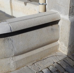 Détail d'une margelle droite moulurée de bac de fontaine en pierre calcaire