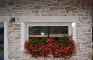 Mur décoratif en pierre calcaire, plate-bande en pierre calcaire bouchardée avec une fleur de lys sculptée